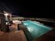 Relaxing nighttime view of a pristine, well-lit pool and patio at 12062 Nouveau Ave, Spring Hill, FL 34610