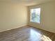 Bedroom features wood-look floors and a window providing natural light at 12336 Southbridge Ter, Hudson, FL 34669