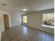Bedroom featuring two bright windows, wood flooring, and neutral walls and trim at 12336 Southbridge Ter, Hudson, FL 34669