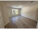 A view of a bedroom with wood-look flooring and a large window at 12336 Southbridge Ter, Hudson, FL 34669