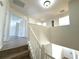 Upstairs hallway with white walls and wood flooring provides access to other rooms in the home at 12336 Southbridge Ter, Hudson, FL 34669