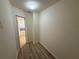 Hallway with view into bathroom, with wood-look flooring at 12336 Southbridge Ter, Hudson, FL 34669