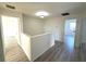 Hallway with gray wood flooring connecting different rooms featuring neutral colored walls and trim at 12336 Southbridge Ter, Hudson, FL 34669