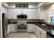 Stylish kitchen featuring white cabinets, granite countertops, and stainless steel appliances at 12336 Southbridge Ter, Hudson, FL 34669