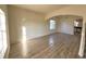 Open living room with new laminate wood-look flooring, arched entryway and natural light at 12336 Southbridge Ter, Hudson, FL 34669