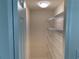 Lighted walk-in pantry features white walls and multiple wire shelving units at 12336 Southbridge Ter, Hudson, FL 34669