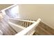 Bright staircase with wood flooring and white railing leading to the upper level of the home at 12336 Southbridge Ter, Hudson, FL 34669