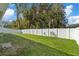 Backyard features a grassy lawn and a white fence at 12739 Balsam Ave, Hudson, FL 34669