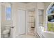 Bright bathroom featuring a shower, toilet and window at 12739 Balsam Ave, Hudson, FL 34669