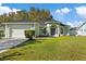 Single-story house with light green exterior, attached garage, and landscaped yard at 12739 Balsam Ave, Hudson, FL 34669