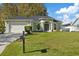 Single-story house with light green exterior, attached garage, and well-maintained lawn at 12739 Balsam Ave, Hudson, FL 34669