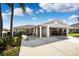 Single-story home with a two-car garage, palm trees, and a driveway at 13610 Evelane Dr, Hudson, FL 34667