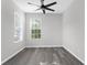 Simple bedroom with ceiling fan, gray vinyl flooring, and window with blinds at 13722 Crest Lake Dr, Hudson, FL 34669