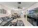 Bright living room with grey sofa, wood-look floors, and a view into the kitchen at 2106 Forester Way, Spring Hill, FL 34606