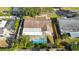 A sprawling neighborhood is captured, dotted with mature trees and featuring residences with screened pools at 465 Meadowlark Ln, Palm Harbor, FL 34683