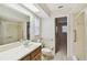 Bathroom featuring a sink with wood cabinets, toilet, and shower with grab bar at 465 Meadowlark Ln, Palm Harbor, FL 34683