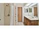 A bathroom with a shower, a sink, wood cabinets, and a mirror at 465 Meadowlark Ln, Palm Harbor, FL 34683