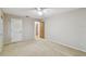 Bedroom featuring neutral carpet, white ceiling fan, and a view of the hall at 465 Meadowlark Ln, Palm Harbor, FL 34683