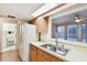 Kitchen with wood cabinets, white appliances and access to laundry and bathroom at 465 Meadowlark Ln, Palm Harbor, FL 34683