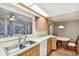 Kitchen with wood cabinets, stainless steel sink, and views to pool at 465 Meadowlark Ln, Palm Harbor, FL 34683