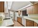 Kitchen boasts wood cabinets, white appliances, and a pass-through window at 465 Meadowlark Ln, Palm Harbor, FL 34683