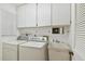Bright laundry room with washer, dryer, sink, and white cabinets at 465 Meadowlark Ln, Palm Harbor, FL 34683