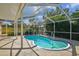 Inviting screened-in pool featuring a unique shape, built-in steps, and a tranquil backyard setting at 465 Meadowlark Ln, Palm Harbor, FL 34683