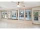 Bright sunroom with ceiling fan and tiled floors featuring multiple windows and a window seat at 465 Meadowlark Ln, Palm Harbor, FL 34683