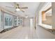 Open sunroom with tile floors, a window seat, and sliding glass doors leads to the backyard at 465 Meadowlark Ln, Palm Harbor, FL 34683