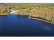 Aerial view of lakefront property with long wooden dock at 5211 Karlsburg Pl, Palm Harbor, FL 34685