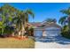 Spacious house with a three-car garage and mature landscaping at 5211 Karlsburg Pl, Palm Harbor, FL 34685