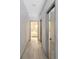 Clean hallway with light gray walls and wood-look tile flooring at 5211 Karlsburg Pl, Palm Harbor, FL 34685