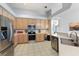 Modern kitchen with stainless steel appliances and light wood cabinets at 5211 Karlsburg Pl, Palm Harbor, FL 34685
