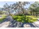 Paved pathway winds through a scenic park with lush trees and gazebo at 5211 Karlsburg Pl, Palm Harbor, FL 34685