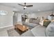 Open living room with gray sectional sofa and kitchen view at 5324 Dellbrook Ave, Spring Hill, FL 34608