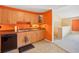 Efficient kitchen with wood cabinets and orange walls at 5576 Baywater Dr # 5576, Tampa, FL 33615