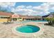 Community pool and hot tub, surrounded by lounge chairs and a brick patio at 5576 Baywater Dr # 5576, Tampa, FL 33615