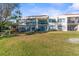 Two-story condo building with balconies, lush lawn, and scenic view at 5838 La Puerta Del Sol S Blvd # 162, St Petersburg, FL 33715