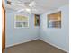 Small bedroom with light blue walls, carpet flooring, and two windows at 7195 Bethesda Ct, Weeki Wachee, FL 34607