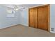 Simple bedroom with light blue walls, ceiling fan, and carpet flooring at 7195 Bethesda Ct, Weeki Wachee, FL 34607