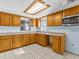 L-shaped kitchen with wood cabinets and tile flooring at 7195 Bethesda Ct, Weeki Wachee, FL 34607