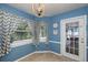 Bright breakfast nook with blue walls, patterned curtains, and view of the pool at 7209 Hummingbird Ln, New Port Richey, FL 34655