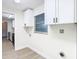 Laundry room with white cabinets and view to kitchen at 7400 Mitchell Ranch Rd, New Port Richey, FL 34655