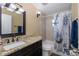 Bathroom with granite countertop, dark brown vanity, and shower/tub combo at 7745 Jenner Ave, New Port Richey, FL 34655