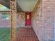 Front entry with red door and decorative metal columns at 8030 Gulf Way, Hudson, FL 34667