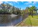 Chain link fence along a pond with fountain at 8700 Cessna Dr, New Port Richey, FL 34654