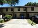Tan townhome with dark brown trim, 2-car driveway, and small front yard at 12719 Lockey Ln, Tampa, FL 33612