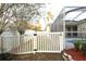 White picket fence encloses a grassy backyard with a screened pool at 1705 Audubon Trl, Lutz, FL 33549