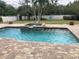 Relaxing pool and spa with brick patio and lush landscaping at 1922 Oswego Dr, Holiday, FL 34691