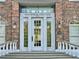 Wentworth Golf Club entrance featuring white door and trim with brick facade and sidelight illumination at 3042 Wentworth Way, Tarpon Springs, FL 34688
